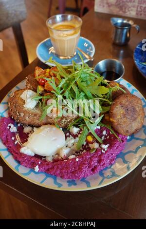 Rübenwurzel Hummus aus Scratch, Quinoa, Edamame-Bohnen, Karotten und Rot- und Weißkohl, Tahini-Dressing und Mini-Veggie-Schnitzel Stockfoto