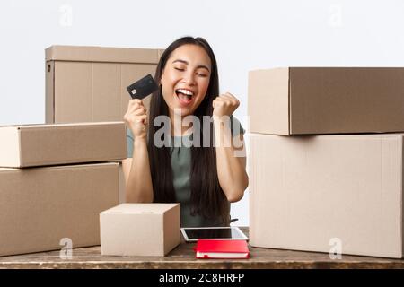 Kleinunternehmer, Startup und E-Commerce Konzept. Erfolgreiche asiatische Geschäftsfrau verdienen Geld aus dem Verkauf online, eigenen Internet-Shop, jubeln als Stockfoto