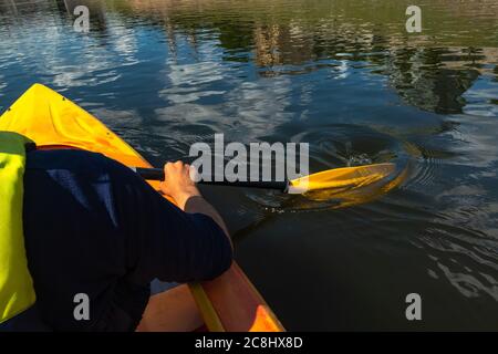 Nahaufnahme einer Person, die an einem sonnigen Tag im Fluss Kanu fahren kann. Hände halten ein Paddel und Rudern in fließendem Wasser Stockfoto