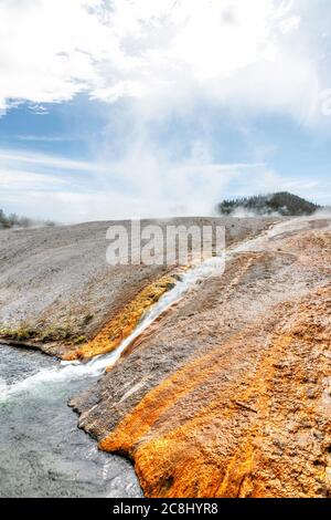 Heißwasserabfluss vom Excelsior Geyser, der in den Firehole River im Midway Geyser Basin des Yellowstone National Park fließt. Stockfoto