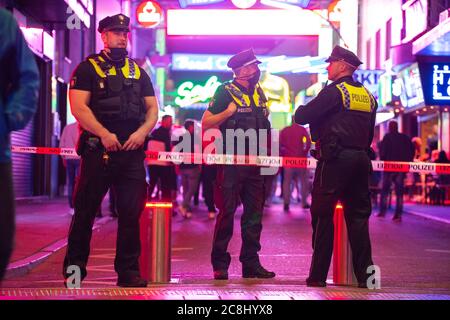 Hamburg, Deutschland. Juli 2020. Polizeibeamte haben den Zugang zur Großen Freiheit auf der Reeperbahn teilweise blockiert, um den Zustrom zu kontrollieren. In der Nacht von Freitag auf Samstag feierten weniger Menschen mit mehr Distanz im Schanzenviertel und auf St. Pauli als am vergangenen Wochenende. Quelle: Jonas Walzberg/dpa/Alamy Live News Stockfoto