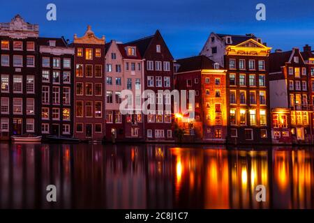 Reihenhäuser an einem Kanal in Damrak, Amsterdam Stockfoto