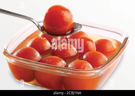 Gulab Jamun serviert in einem quadratischen Messingplatte mit Gießen süßen Sirup - ein indisches süßes Gericht Stockfoto