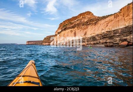 Eine geführte Kajakfahrt auf der Isla Espirito Santo, Golf von Kalifornien, BCS, Mexiko, vor der Küste unter den hohen Sandsteinklippen. Stockfoto