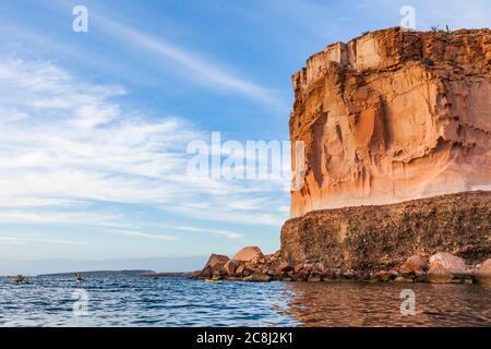 Eine geführte Kajakfahrt auf der Isla Espirito Santo, Golf von Kalifornien, BCS, Mexiko, vor der Küste unter den hohen Sandsteinklippen. Stockfoto