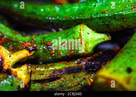 Frische gebratene Okras oder Damenfinger mit Salz und Chilipulver in einer Pfanne Stockfoto