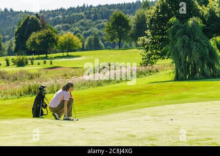 Junge Golfspielerin auf Grün Stockfoto