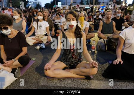 Demonstranten mit Gesichtsmaske wegen der COVID-19-Coronavirus-Pandemie führen Yoga durch, als Tausende von Demonstranten vor dem offiziellen Wohnsitz von Premierminister Benjamin Netanjahu in Jerusalem massierten, um seinen Rücktritt wegen seiner Korruptionsvorwürfe und der so genannten Misswirtschaft der Coronavirus-Krise zu fordern und der Demokratie in Jerusalem, Israel, zu schaden. Stockfoto