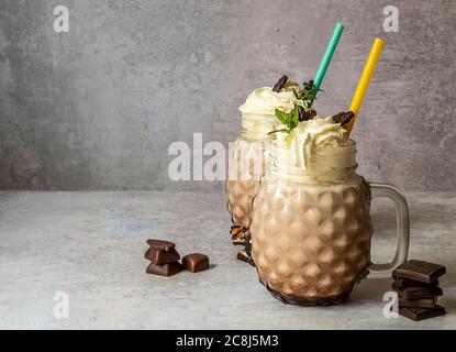 Süßer Schokoladenmilchshake mit Eis, Kaffee und Schlagsahne in einem Glas-Einmachglas. Stockfoto
