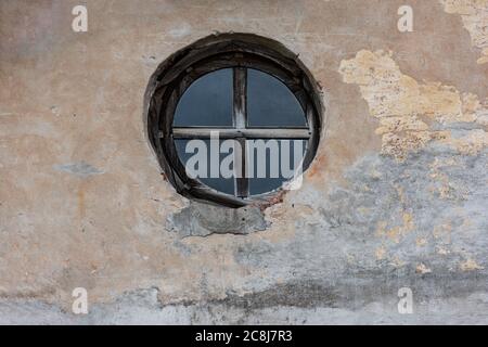 Altes rundes Fenster in einer Betonwand Stockfoto