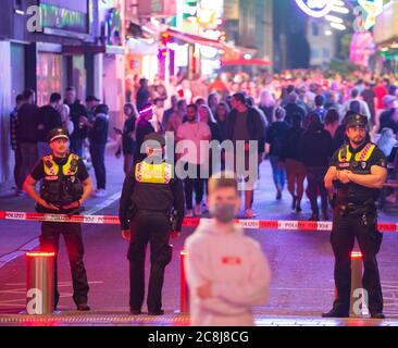 24. Juli 2020, Hamburg: Polizeibeamte haben den Zugang zur Großen Freiheit auf der Reeperbahn teilweise blockiert, um den Zustrom zu kontrollieren. In der Nacht von Freitag auf Samstag feierten weniger Menschen mit mehr Distanz im Schanzenviertel und auf St. Pauli als am vergangenen Wochenende. Foto: Jonas Walzberg/dpa Stockfoto