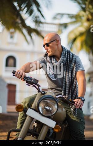 Mann mit Brille auf einem Motorradwald in der Natur Stockfoto