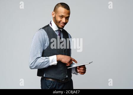 Professioneller afroamerikanischer Geschäftsmann, der Tablet-pc hält Stockfoto