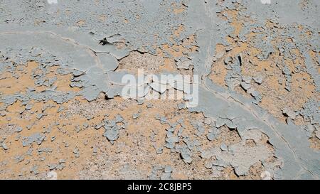 Verwitterte raue Textur der alten Wand mit grauer abblätternder Farbe Nahaufnahme auf sandiger Farbe Steinoberfläche. Reparatur- und Rekonstruktionskonzept Stockfoto