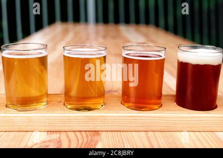 Bierprobe. Diferent Bier in 100 Mililiter Brille über Holztisch. Stockfoto