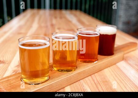 Bierprobe. Diferent Bier in 100 Mililiter Brille über Holztisch. Stockfoto