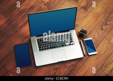 Büro-Zeug mit Notepad, Laptop, Smartphone, Stift und Uhr auf dem braunen Holz Schreibtisch. Draufsicht mit Textfreiraum. Stockfoto