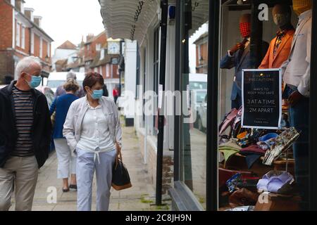 Rye, East Sussex, Großbritannien. 25 Juli 2020. Wetter in Großbritannien: Besucher der antiken Stadt Rye in East Sussex wandern durch die Hauptstraße mit einem älteren Paar, das trotz des Nieselregens Masken trägt. Viele Menschen halten sich an die Ratschläge der neuen Regierung zum Tragen von Masken in Geschäften Stockfoto