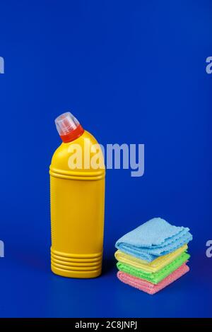 Gelbe Toilettenspülung mit Lumpen auf blauem Hintergrund. Stockfoto