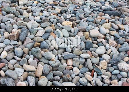 Steine, Felsen und Kieselsteine an einem felsigen Strand in Trefor, Nordwales Stockfoto