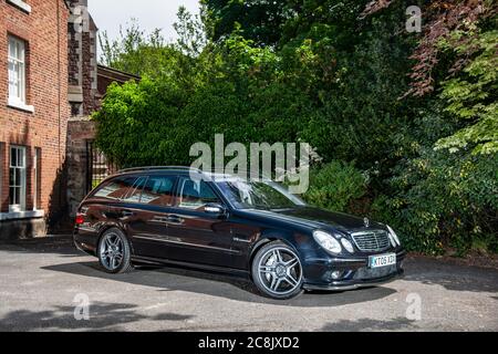 Mercedes-Benz E55-Kombi parkte auf einer Fahrt vor dem Fahrzeug Eines georgianischen Hauses in einem grünen Vorort auf einem Sommernachmittag Stockfoto