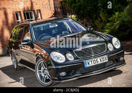 Mercedes-Benz E55-Kombi parkte auf einer Fahrt vor dem Fahrzeug Eines georgianischen Hauses in einem grünen Vorort auf einem Sommernachmittag Stockfoto