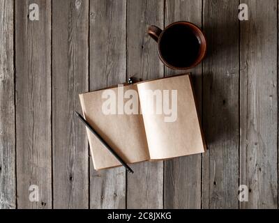 Schreibtisch mit leerem Bildschirm Smartphone, Stift, Notebook und Kaffeetasse auf Holztisch.Draufsicht mit Kopierplatz.Bürobedarf und Gadgets auf Schreibtisch Tisch.Arbeitstisch Konzept.Flat Lay Bild. Stockfoto