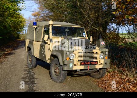 Land Rover Military Police-Funkfahrzeug mit langem Radstand, der auf einer Landstraße geparkt ist. Stockfoto