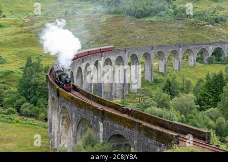 JACOBITE DAMPFZUG WEST HIGHLAND LINIE SCHOTTLAND IM SOMMER DER ZUG UND WOLKE VON WEISSEM RAUCH AUS DEM TRICHTER, WIE ES DEN GLENFINNAN VIADUKT ÜBERQUERT Stockfoto