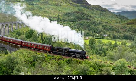JACOBITE DAMPFZUG WEST HIGHLAND LINIE SCHOTTLAND IM SOMMER ZUG UND WOLKE VON DICHTEM WEISSEN RAUCH AUS DEM TRICHTER, WIE ES DAS ENDE VON GLENFINNAN VI ÜBERQUERT Stockfoto