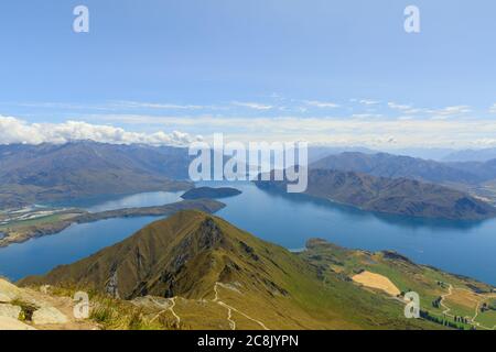 Der Blick vom Gipfel des Roys Peak über den Wanaka See und die Berge der Südalpen, während Wolken über ihnen Rollen. Stockfoto