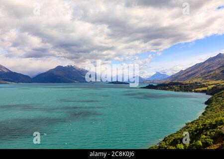 Der Blick auf den Wakatipu-See mit Wolken, die die schneebedeckten Berge in der Ferne bedecken. Aus der Sicht des Bennetts Bluff Lookout. Stockfoto