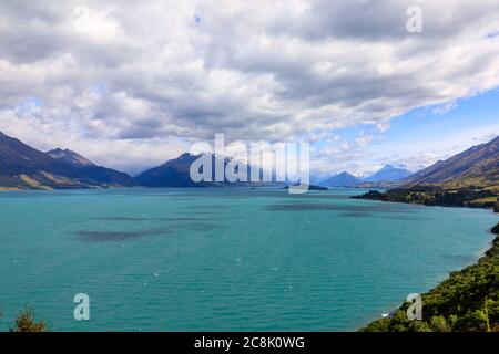 Der Blick auf den Wakatipu-See mit Wolken, die die schneebedeckten Berge in der Ferne bedecken. Aus der Sicht des Bennetts Bluff Lookout. Stockfoto