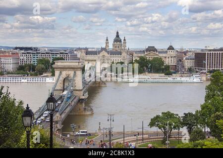 Kettenbrücke an der Donau mit zahlreichen Touristen in der Stadt Budapest. Ein Blick auf die Stadtlandschaft von Pest mit alten Gebäuden Stockfoto