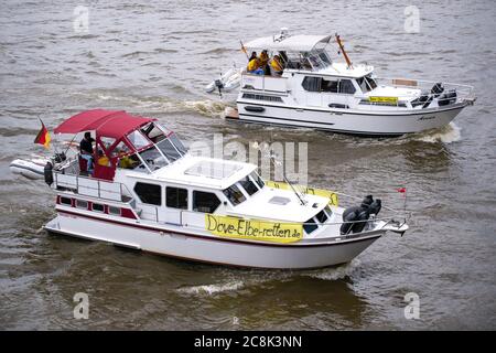 25. Juli 2020, Hamburg: Plakate mit der Aufschrift 'ove-Elbe-retten.de' sind an Motorbooten angebracht, die auf der Norderelbe fahren. 100 Boote seien bei einer Demonstration der Bürgerinitiative "Dove-Elbe-Retten" nach Angaben der Polizei in Richtung der Landestreben gestartet. Die Demonstration richtete sich nach Angaben der Initiatoren gegen Überlegungen, die Taubenelbe an der Tatenberger Schleuse in Richtung Norderelbe zu öffnen und damit zu einem Gezeitenwasser zu machen. Dies würde lokale Vereine und Unternehmen sowie die Flora und Fauna bedrohen. Foto: Jonas Walzberg/dpa Stockfoto