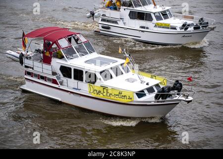 25. Juli 2020, Hamburg: Plakate mit der Aufschrift 'ove-Elbe-retten.de' sind an Motorbooten angebracht, die auf der Norderelbe fahren. 100 Boote seien bei einer Demonstration der Bürgerinitiative "Dove-Elbe-Retten" nach Angaben der Polizei in Richtung der Landestreben gestartet. Die Demonstration richtete sich nach Angaben der Initiatoren gegen Überlegungen, die Taubenelbe an der Tatenberger Schleuse in Richtung Norderelbe zu öffnen und damit zu einem Gezeitenwasser zu machen. Dies würde lokale Vereine und Unternehmen sowie die Flora und Fauna bedrohen. Foto: Jonas Walzberg/dpa Stockfoto