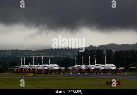 Glasgow, Schottland, Großbritannien. 23. Juli 2020. Im Bild: Unter einer drohenden dunklen, stürmischen Wolke sitzen die geerdeten Flugzeuge des Typs British Airways (BA) Airbus A319/A320/A321 auf der zweiten Landebahn des Flughafens Glasgow und warten darauf, verkauft oder gelagert zu werden. Seit März sitzen diese Flugzeuge auf dem Asphalt der Flughäfen untätig, was der weltweiten Krise des Coronavirus (COVID19) zusteht. British Airways hat fast 12,000 Mitarbeiter gekürzt und bis heute ihre gesamte Boeing 747-Flotte in den Ruhestand, um die Betriebskosten zu senken. Quelle: Colin Fisher/Alamy Live News. Stockfoto