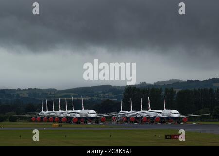 Glasgow, Schottland, Großbritannien. 23. Juli 2020. Im Bild: Unter einer drohenden dunklen, stürmischen Wolke sitzen die geerdeten Flugzeuge des Typs British Airways (BA) Airbus A319/A320/A321 auf der zweiten Landebahn des Flughafens Glasgow und warten darauf, verkauft oder gelagert zu werden. Seit März sitzen diese Flugzeuge auf dem Asphalt der Flughäfen untätig, was der weltweiten Krise des Coronavirus (COVID19) zusteht. British Airways hat fast 12,000 Mitarbeiter gekürzt und bis heute ihre gesamte Boeing 747-Flotte in den Ruhestand, um die Betriebskosten zu senken. Quelle: Colin Fisher/Alamy Live News. Stockfoto