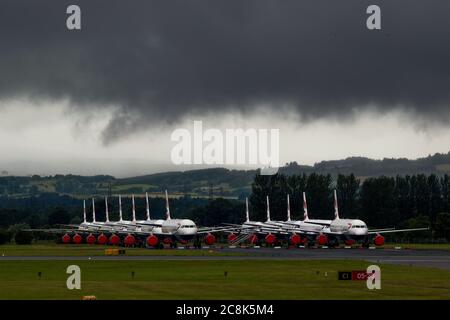 Glasgow, Schottland, Großbritannien. 23. Juli 2020. Im Bild: Unter einer drohenden dunklen, stürmischen Wolke sitzen die geerdeten Flugzeuge des Typs British Airways (BA) Airbus A319/A320/A321 auf der zweiten Landebahn des Flughafens Glasgow und warten darauf, verkauft oder gelagert zu werden. Seit März sitzen diese Flugzeuge auf dem Asphalt der Flughäfen untätig, was der weltweiten Krise des Coronavirus (COVID19) zusteht. British Airways hat fast 12,000 Mitarbeiter gekürzt und bis heute ihre gesamte Boeing 747-Flotte in den Ruhestand, um die Betriebskosten zu senken. Quelle: Colin Fisher/Alamy Live News. Stockfoto