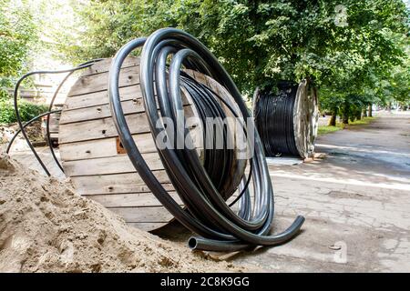 Zwei große hölzerne industrielle Rollen mit Kabel in der Stadt Straße an sonnigen Sommertag Stockfoto