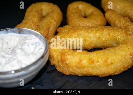 Zwiebelringe und ein Glas-Topf mit Sauce. Nahaufnahme Stockfoto