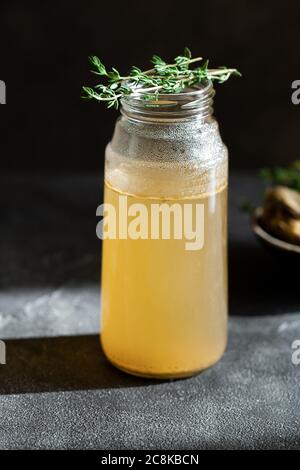 Frische Gemüsebone Brühe im Glas mit Kraut auf dunkelgrauem Hintergrund. Gesunde Ernährung Lebensmittel sind reich an Vitaminen, Kollagen und entzündungshemmende Stockfoto