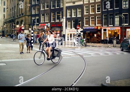 Amsterdam, Niederlande. Juli 15, 2016. Tägliches Leben mit Menschen Wandern und Radfahren in der Innenstadt von Amsterdam Straße mit Geschäften, Bars und Restaurant Stockfoto