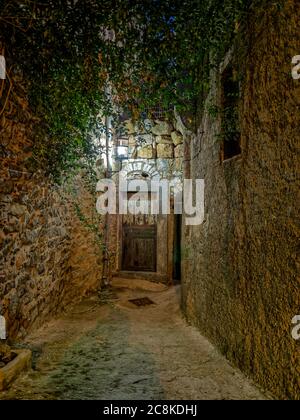 Eine beleuchtete Sackgasse in Mesta, einem der schönsten Dörfer auf der Insel Chios. Seine aufwendige urbane Textur vermittelt den Eindruck eines Labyrinths. Stockfoto