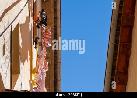 An der Fassade eines Hauses hängen getünchte Kleidung Eine schmale Straße in Granada Stockfoto