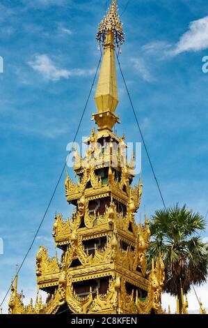 Goldene Motive auf den Stupa-Türmen mit dem Himmel dahinter, Shwedagon Pagode, Yangon, Myanmar. Stockfoto