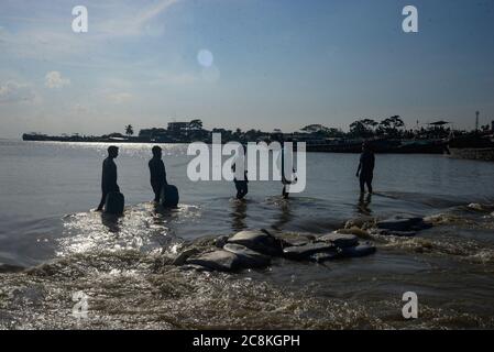 Dhaka, Bangladesch. Juli 2020. Die Menschen gehen durch eine untergetauchte Straße.die Überschwemmungssituation in Munshiganj verschlechtert sich. Durch den starken Regen ist der Wasserstand des Padma-Flusses gestiegen, was zu einer Überschwemmung führte. Mindestens 1.5 Millionen Menschen sind betroffen, Häuser und Straßen in Dörfern überschwemmt. Beamte des Hochwasserprognosen- und Warnzentrums (FFWC) haben berichtet, dass die Überschwemmungssituation in 15 nördlichen und zentralen Bezirken durch den Anstieg des Wasserstials der Hauptflüsse verursacht wurde. Kredit: SOPA Images Limited/Alamy Live Nachrichten Stockfoto