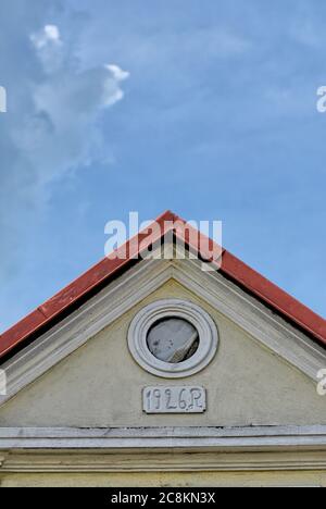 Giebwand mit kleinem runden Fenster gegen blauen Himmel mit Kopierraum Stockfoto