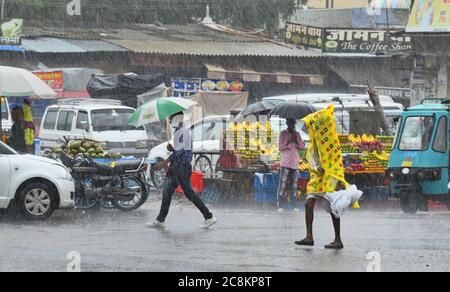 Beawar, Rajasthan, Indien, 24. Juli 2020: Fußgänger waten durch wassergeloggte Straße bei starkem Regen in Beawar. Kredit: Sumit Saraswat/Alamy Live Nachrichten Stockfoto