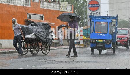 Beawar, Rajasthan, Indien, 24. Juli 2020: Fußgänger gehen bei starkem Regen auf einer Straße in Beawar. Kredit: Sumit Saraswat/Alamy Live Nachrichten Stockfoto